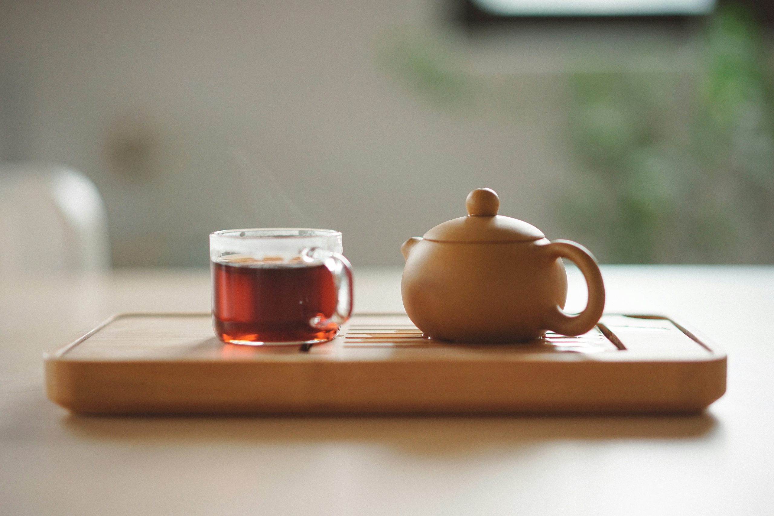 Glass tea cup with small ceramic tea pot on wood board Storage unit with NO symbol