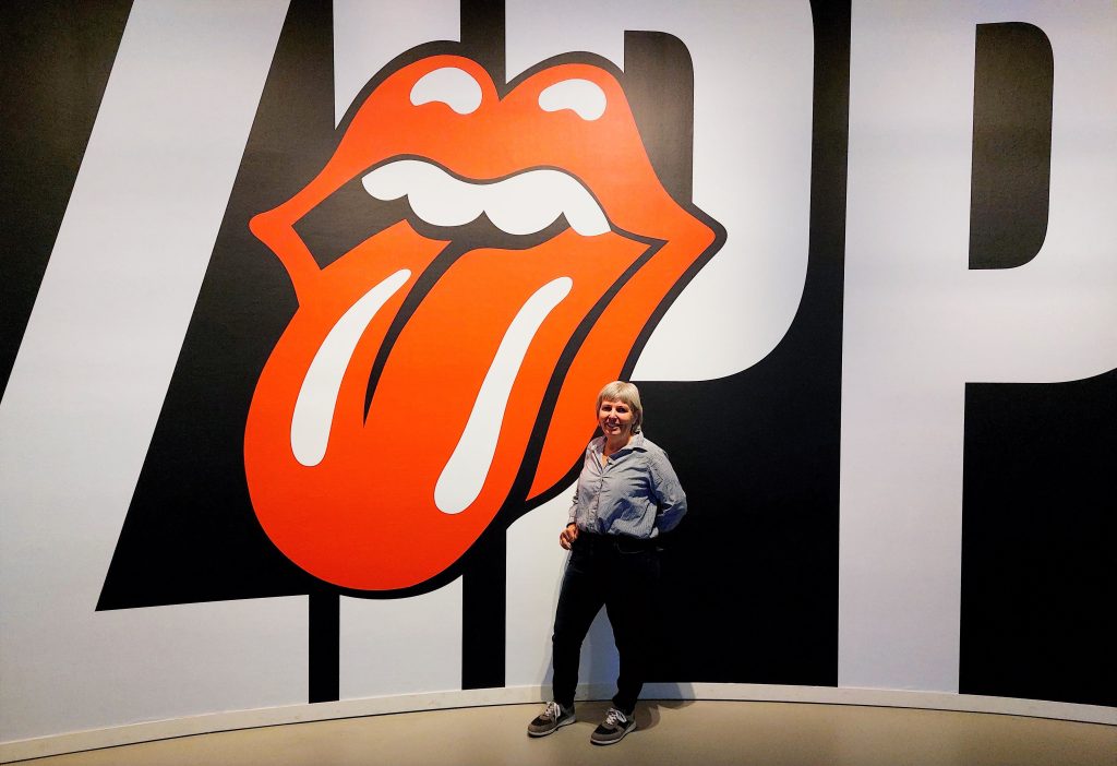 Sheila standing in front of Rolling Stones Logo at Groninghen Museum